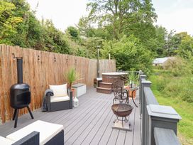 An outdoor space with deck, seating, hot tub, and plants at Red Kite at Wild Valley Huts in Llanrhaeadr-Ym-Mochnant