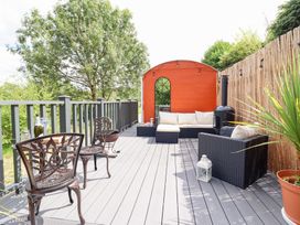 An outdoor patio with seating and a small structure at Red Kite at Wild Valley Huts Llanrhaeadr-Ym-Mochnant