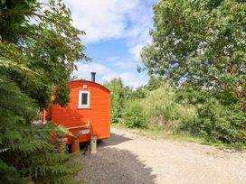 Shepherd's hut surrounded by trees at Red Kite at Wild Valley Huts Llanrhaeadr-Ym-Mochnant