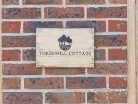A sign labeled Tokenhill Cottage on a brick wall at Tokenhill Cottage Piddletrenthide