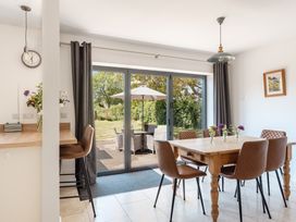 A dining room with a table and chairs overlooking a garden at Tokenhill Cottage Piddletrenthide