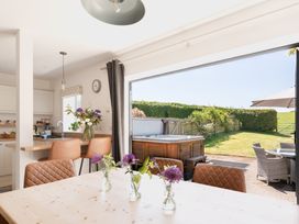 A kitchen with a dining table and flowers at Tokenhill Cottage in Piddletrenthide