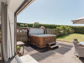 A garden with a hot tub and patio furniture at Tokenhill Cottage in Piddletrenthide