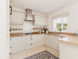 A kitchen with cabinets and stove at Tokenhill Cottage in Piddletrenthide