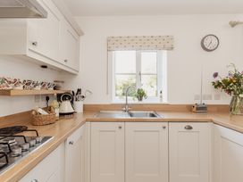 A kitchen with a sink and a gas stove at Tokenhill Cottage in Piddletrenthide