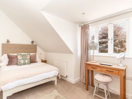 A bedroom with a bed and desk at Tokenhill Cottage in Piddletrenthide