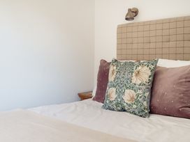 A bedroom with a bed and decorative pillows at Tokenhill Cottage in Piddletrenthide