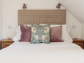 A bedroom with a bed and pillows at Tokenhill Cottage Piddletrenthide