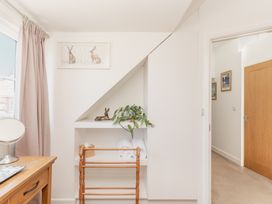 A bathroom with a shelf and towels at Tokenhill Cottage in Piddletrenthide