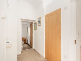 A hallway with doors and paintings at Tokenhill Cottage in Piddletrenthide