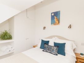 A bedroom with a bed and a plant at Tokenhill Cottage in Piddletrenthide