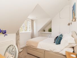 A bedroom with a bed and window at Tokenhill Cottage in Piddletrenthide