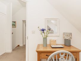 A hallway with a table and lamp at Tokenhill Cottage in Piddletrenthide
