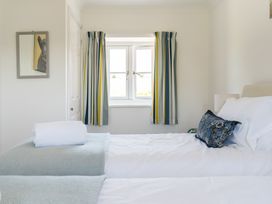 A bedroom with twin beds and a window at Tokenhill Cottage in Piddletrenthide