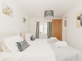 A bedroom with two beds and a window at Tokenhill Cottage in Piddletrenthide
