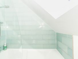 A bathroom with shower and bathtub at Tokenhill Cottage in Piddletrenthide