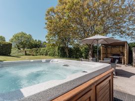 An outdoor area with a hot tub and grill at Tokenhill Cottage in Piddletrenthide