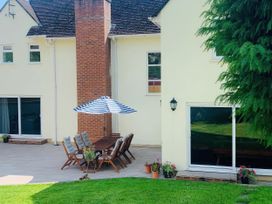 An outdoor patio area with a table and chairs at Brooklands in Uplyme