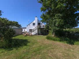 A house with a deck and outdoor seating in the garden at Borth Arian Boat House Holyhead
