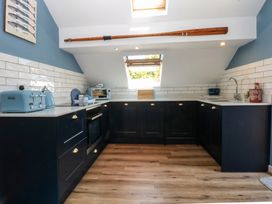 A kitchen with cabinets and appliances at Borth Arian Boat House in Holyhead