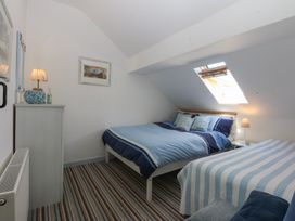 A bedroom with two beds and a window at Borth Arian Boat House in Holyhead