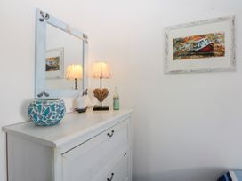 A bedroom with a mirror and lamps on a cabinet at Borth Arian Boat House in Holyhead
