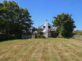 A house with a deck and grass area at Borth Arian Boat House in Holyhead