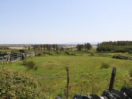 A landscape with a gate and stone wall at Borth Arian Boat House Holyhead