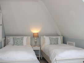 A bedroom with two single beds and a lamp at 2 Channel View Salcombe