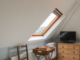 A bedroom with a window and television at 2 Channel View Salcombe