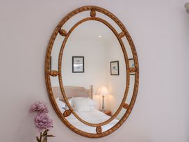 A bedroom with a mirror and lamp at 2 Channel View Salcombe