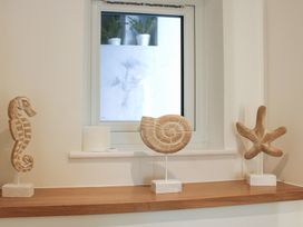 A shelf with seahorse fossil and starfish sculptures at 2 Channel View in Salcombe