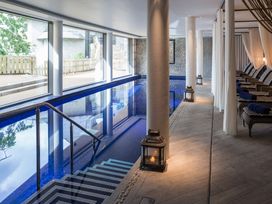 An indoor pool area with chairs and windows at 2 Channel View Salcombe