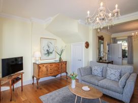 A living room with a sofa and television at 2 Channel View in Salcombe