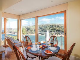 A dining room with a table and a view at 2 Channel View in Salcombe