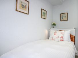 A bedroom with a bed and wall art at 2 Channel View in Salcombe