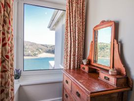 A bedroom with a window and a dressing table at 2 Channel View in Salcombe