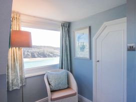 A sitting room with a lamp and chair at 2 Channel View in Salcombe