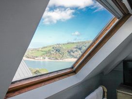 A window showing a scenic view of hills and a river at 2 Channel View in Salcombe