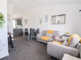 A living room with a sofa and dining area at Bonny Bay in Wilsthorpe near Bridlington