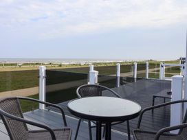 An outdoor terrace with a table and chairs at Bonny Bay in Wilsthorpe near Bridlington