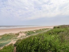 A beach with sand and grass at Bonny Bay near Wilsthorpe