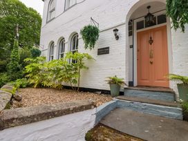 The entrance of Clematis House in St Columb Major with plants and a peach door