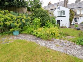 A garden with plants and a stone pathway at Clematis House in St Columb Major