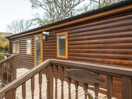 A wooden cabin exterior with a deck and steps at Willow in Swanage