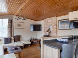 A living room with a television and sofa at Willow in Swanage