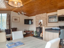 A living room with a television and a fireplace at Willow in Swanage