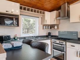 A kitchen with a microwave, oven, and sink at Willow in Swanage