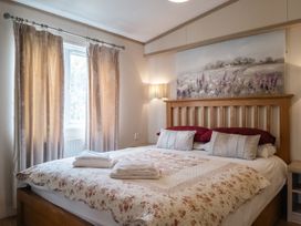 A bedroom with a bed and curtains at Willow in Swanage