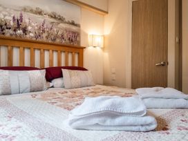 A bedroom with a bed and wall art at Willow in Swanage